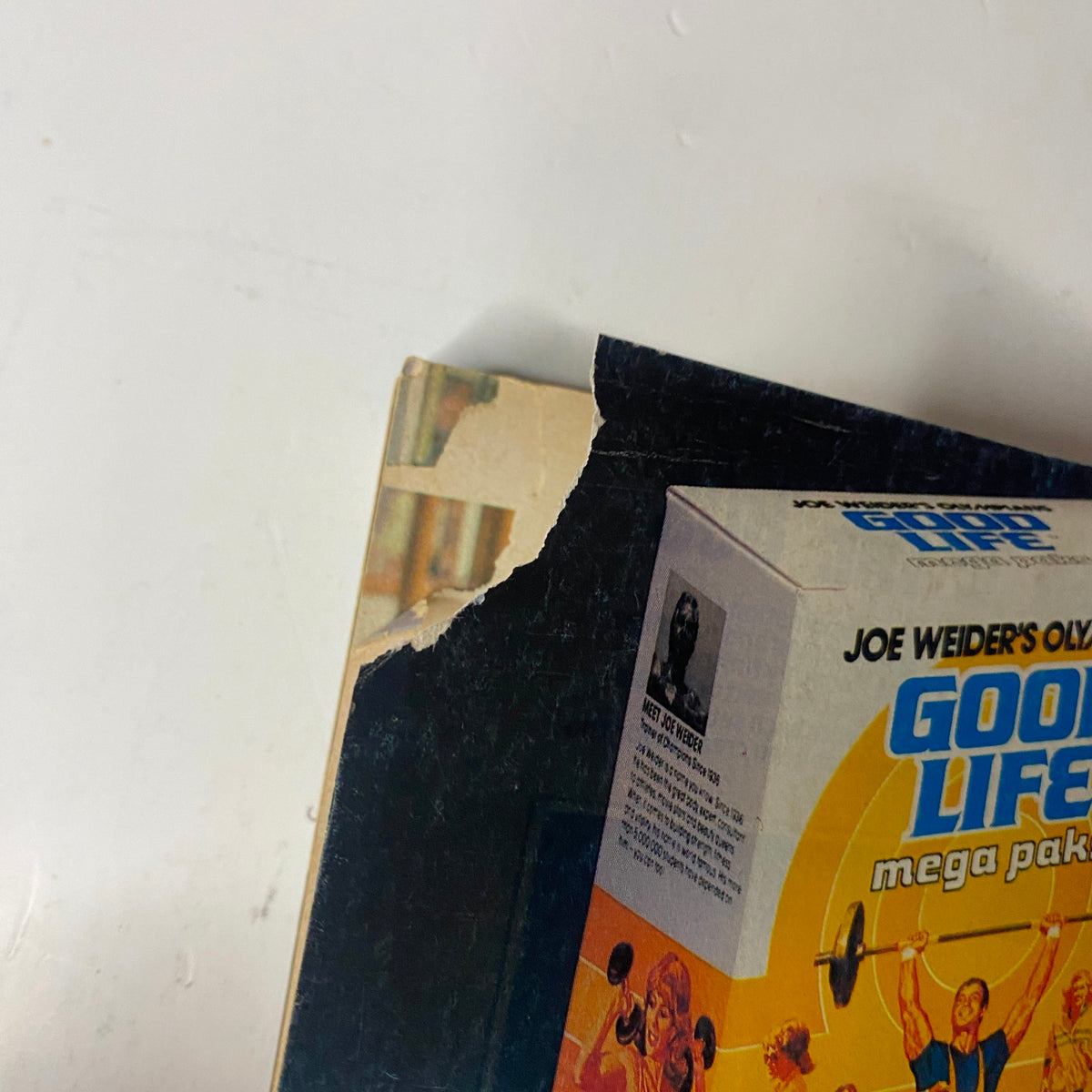 Close-up of the spine of Muscle & Fitness Magazine, March-April 1981, showing slight damage, indicating a vintage condition, along with a promotional image for Joe Weider's Good Life Mega-Paks.