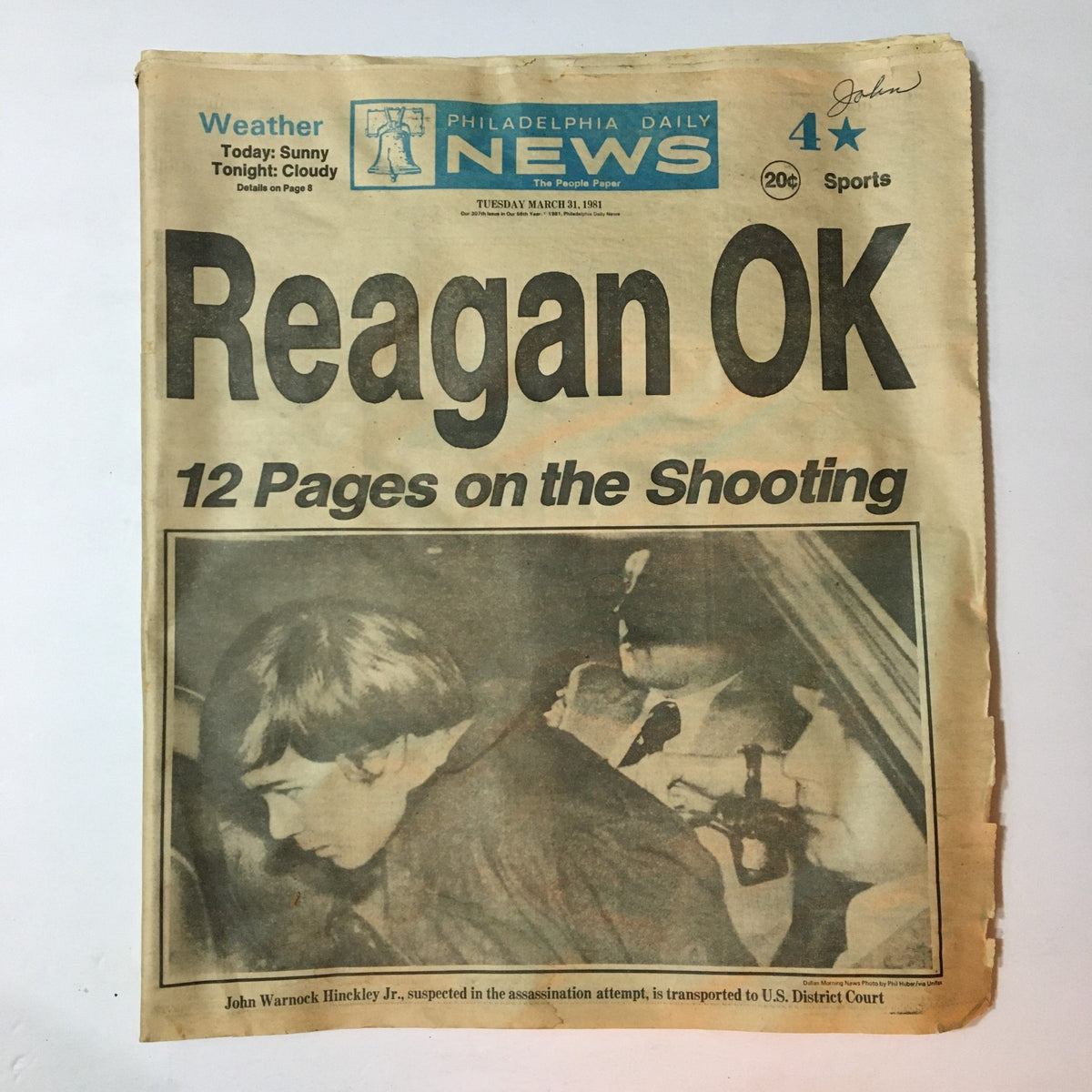 Vintage Philadelphia Daily News from March 31, 1981, featuring a prominent headline about Ronald Reagan's shooting incident. The newspaper includes coverage related to John Warnock Hinckley Jr. with a notable image of Hinckley during his transportation.