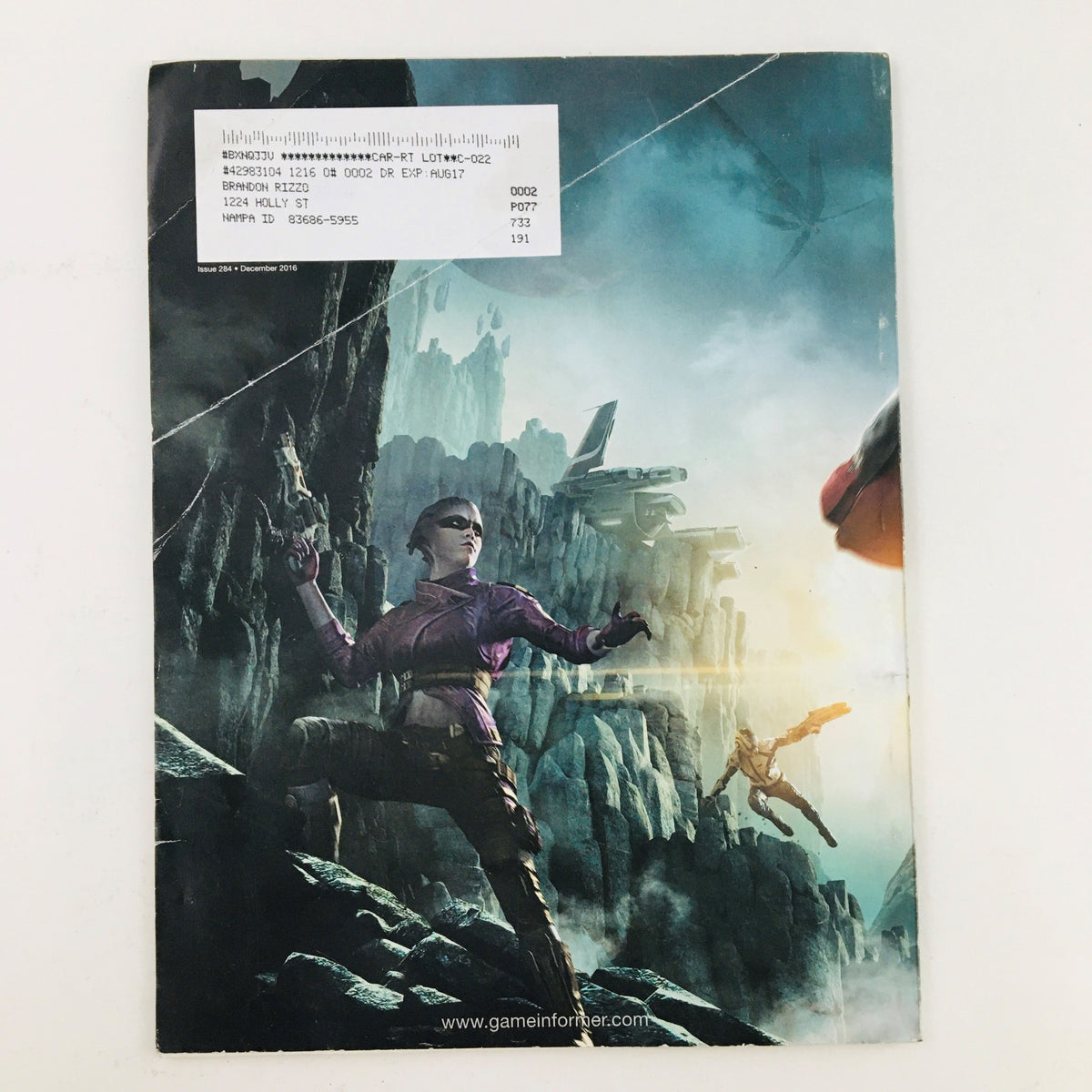 Back cover of Game Informer Magazine December 2016 Issue 284, showcasing a striking image related to Mass Effect Andromeda, with an address label affixed.