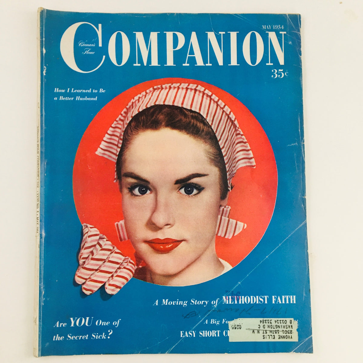 Cover of Woman's Home Companion May 1954 featuring a young woman with a striped headscarf and bold red lipstick, highlighting a morning story of Methodist faith.