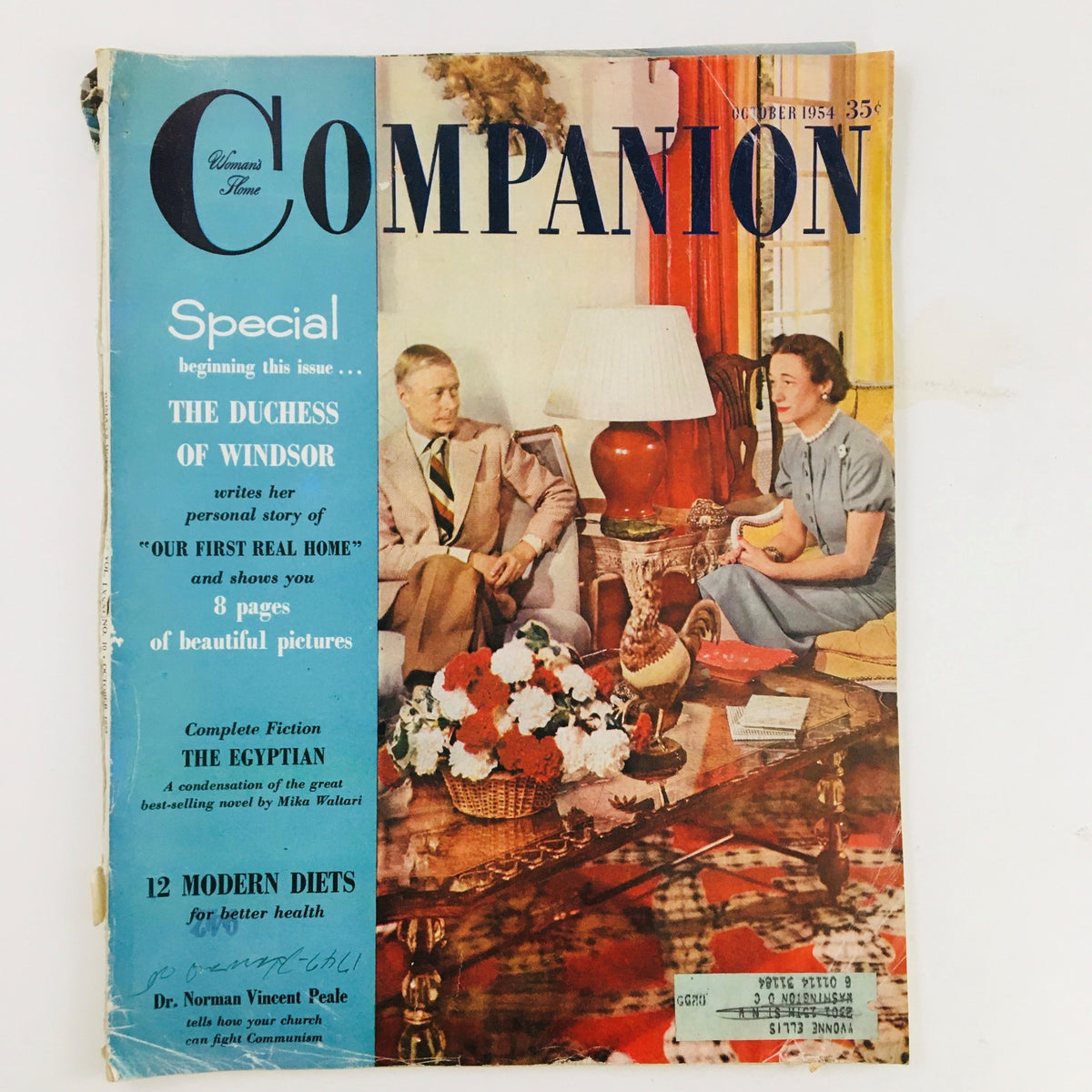 Cover of Woman's Home Companion October 1954 featuring The Duchess of Windsor, showcasing interior design and lifestyle features, with a couple seated in a well-decorated living room.