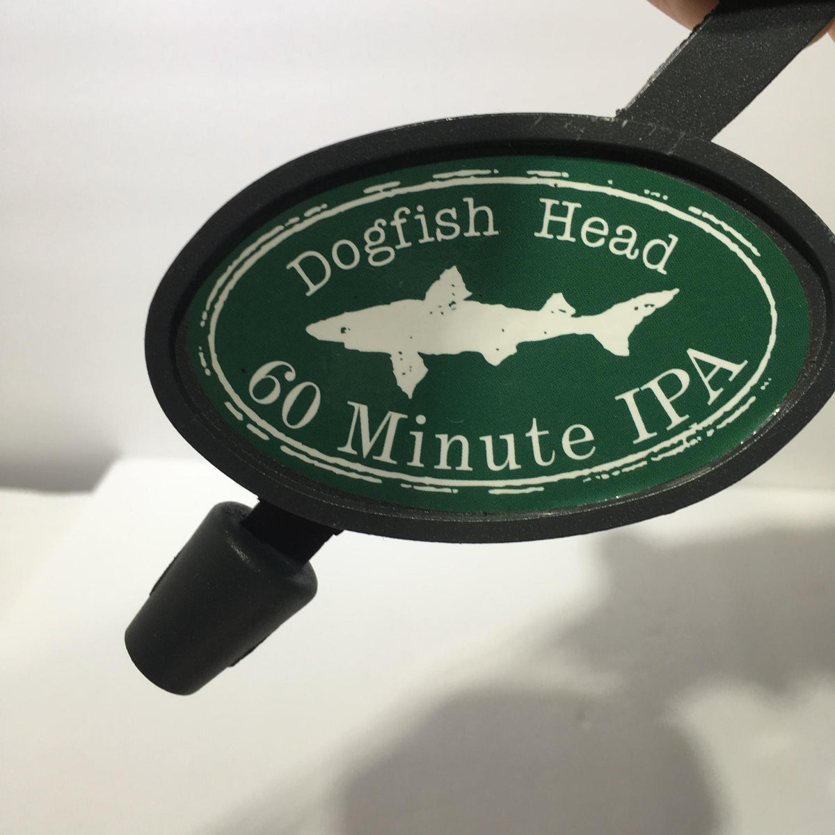 View of the circular label on the Vintage Dogfish Head 60 Minute IPA 12" Beer Tap Handle, featuring the design with a fish silhouette.