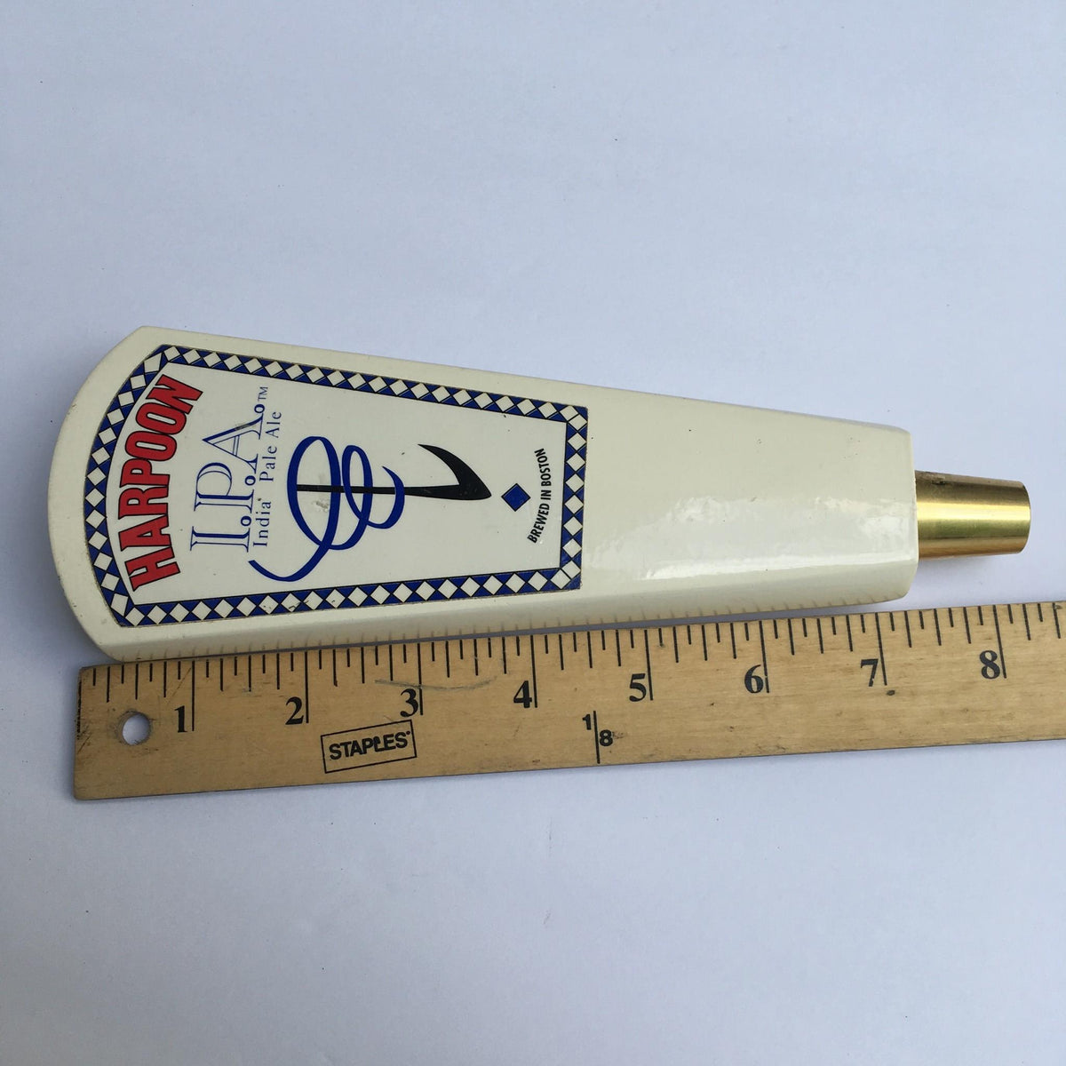 Side view of Vintage Harpoon IPA Indian Pale Ale 8½" Beer Tap Handle next to a ruler for size reference.