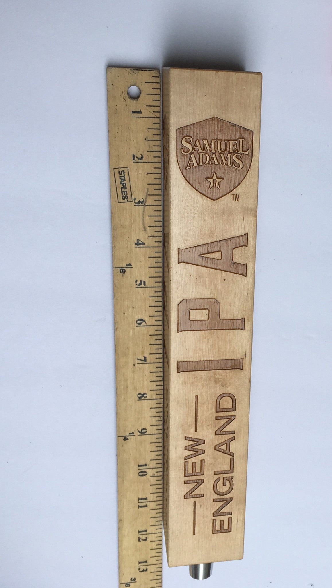 Vintage Samuel Adams New England IPA 13" Beer Tap Handle next to a ruler for scale, demonstrating its length and detailed engraving.
