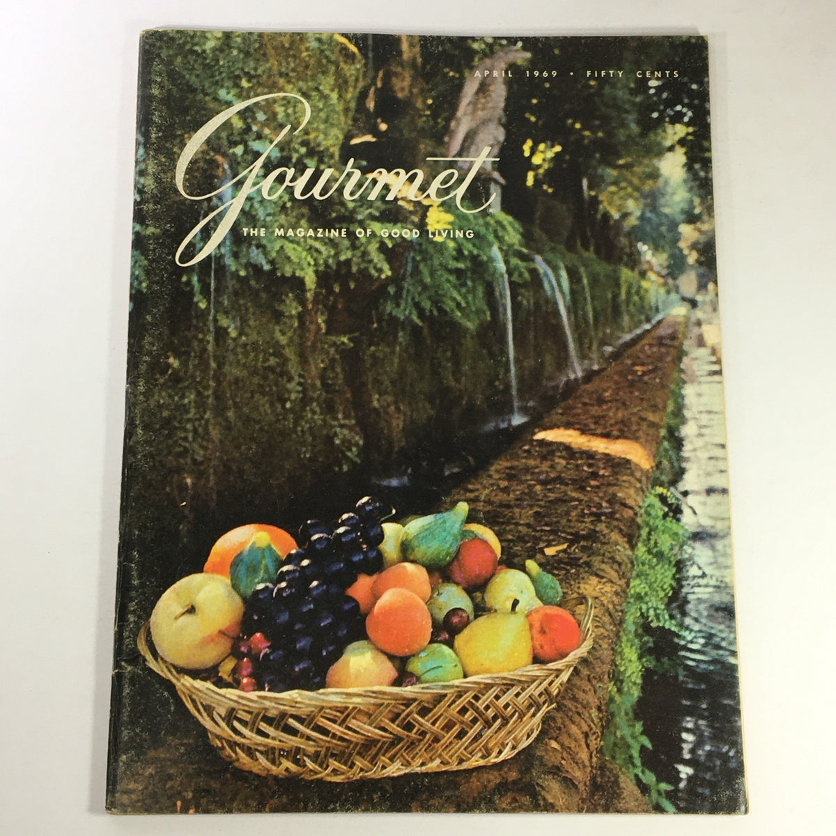 Cover of VTG Gourmet The Magazine of Good Living April 1969 featuring a basket of colorful fruits in a serene outdoor setting.