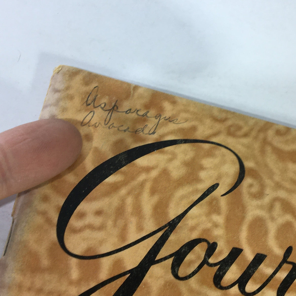 Close-up view of the cover of VTG Gourmet The Magazine of Good Living May 1968, featuring a handwritten note that says 'Asparagus Awaits' near the title.