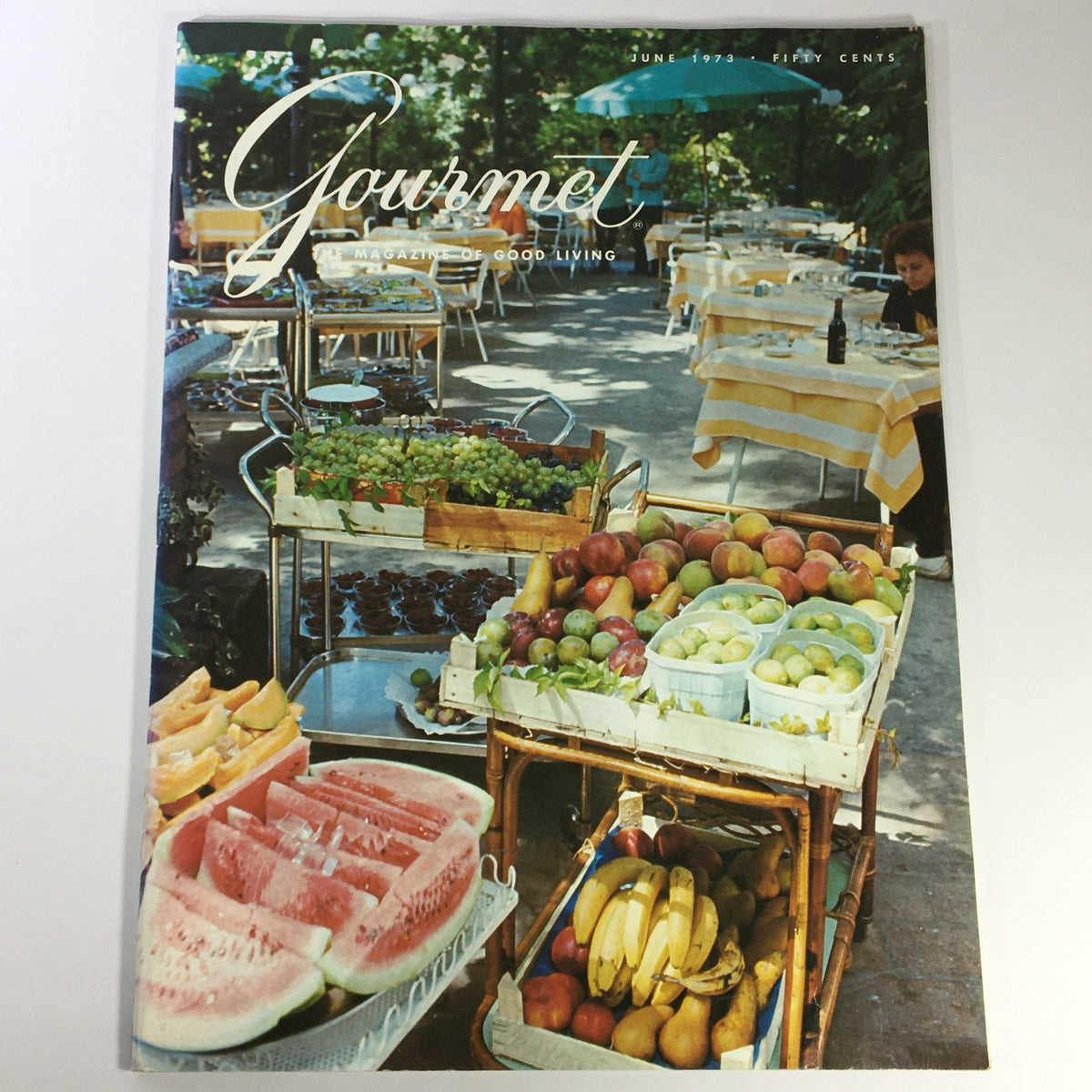 Cover of VTG Gourmet: The Magazine of Good Living, June 1973 edition, showcasing a vibrant outdoor dining scene with fruits and desserts displayed in baskets, emphasizing an Irish Dinner Cruise theme.