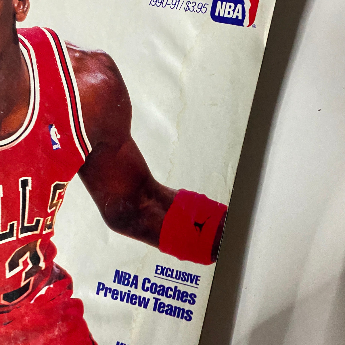 Close-up view of the cover of Street & Smith's Pro Basketball Magazine 1990-1991 featuring Michael Jordan, highlighting the text that includes 'Michael's Too Much!' and 'Exclusive NBA Coaches Preview Teams'.