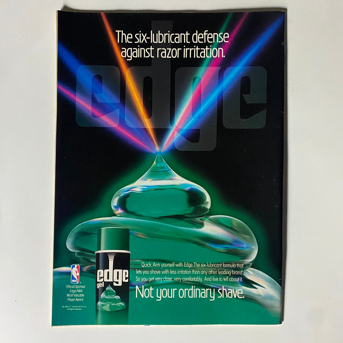 Advertisement for Edge shaving gel from Basketball Digest Magazine, promoting its six-lubricant formula with the slogan 'Not your ordinary shave' in a visually striking design, highlighting its association with the NBA.