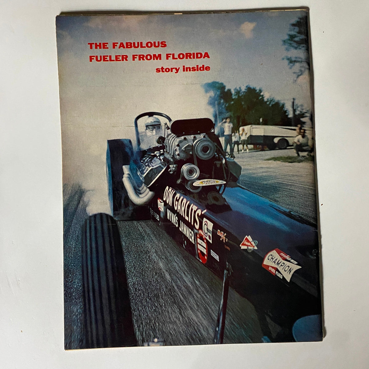Back cover of American Rodding Magazine June 1965, showcasing an action shot of a drag racer and promoting the featured story about 'The Fabulous Fueler from Florida'.