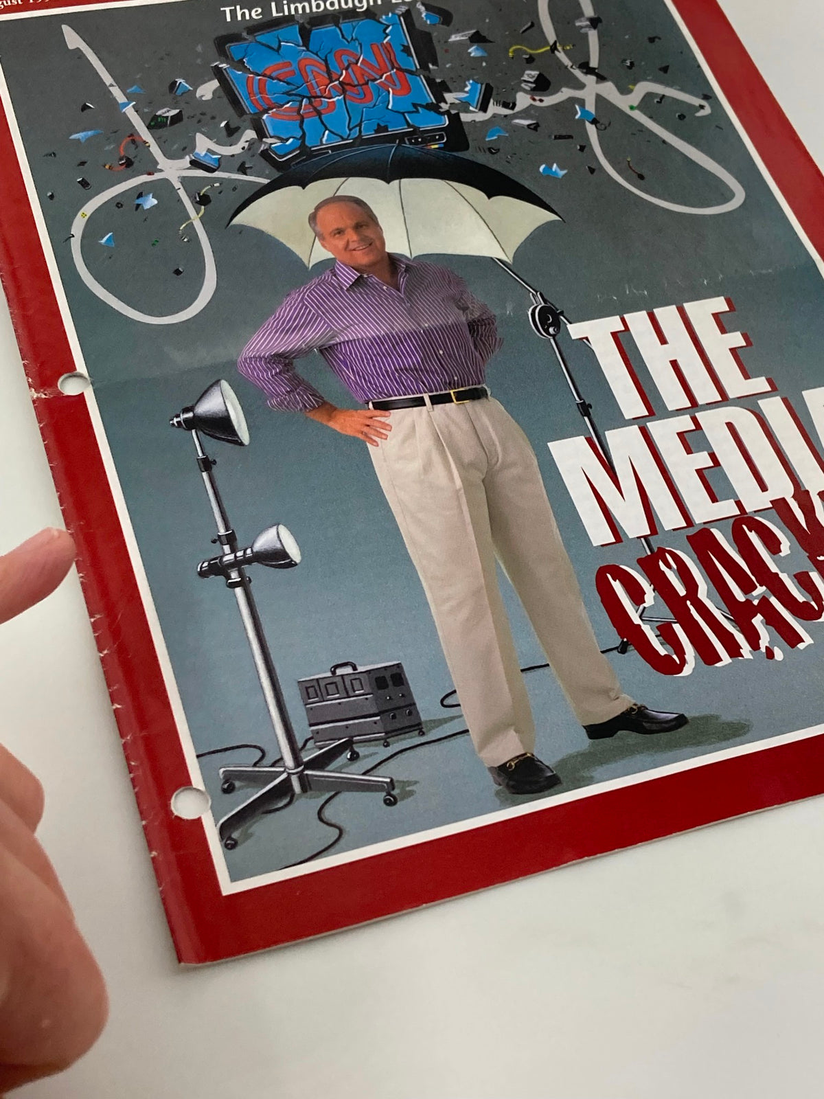 Close-up view of the cover of the Rush Limbaugh Letter Newsletter Magazine from August 1998 showcasing the title 'The Media Crack Up' along with an image of Rush Limbaugh standing confidently under an umbrella, with studio lights and a vintage design.