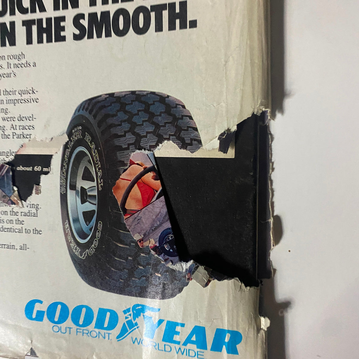 Close-up of damage on the back cover of VTG Four Wheeler Magazine May 1981 showing Goodyear Wrangler Radial tire advertisement with a torn edge.
