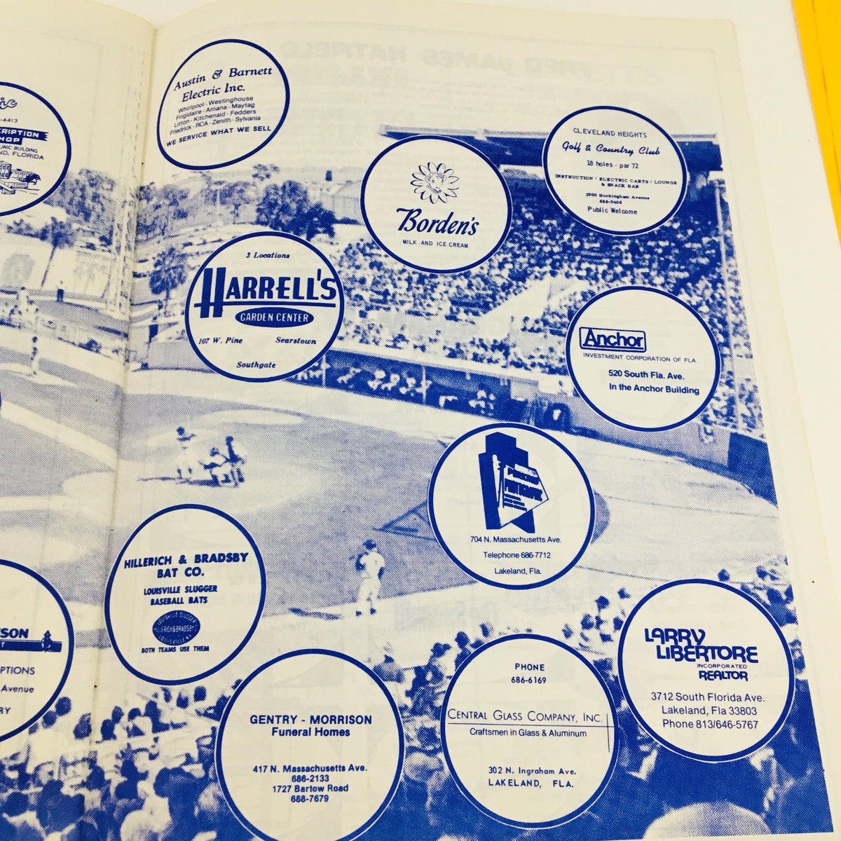 Advertisement page in the 1977 MLB Baseball Lakeland Flying Souvenir Program featuring local business promotions, including logos and contact information, reflecting the community involvement of the event.