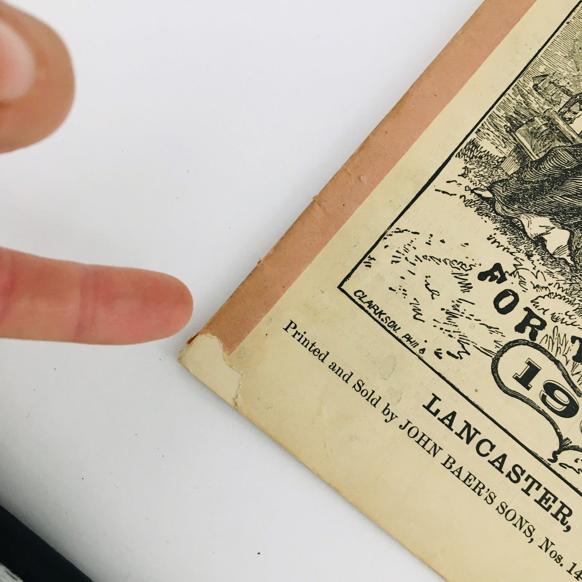 Close-up image of the edge of the Agricultural Almanac for the Year of Our Lord 1908, highlighting the printing details and minor wear on the cover.