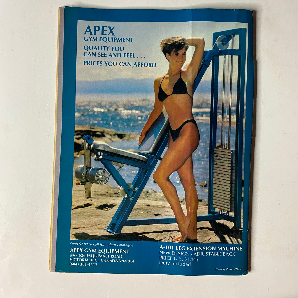 Advertisement for Apex Gym Equipment in MuscleMag International Magazine, November 1986, No. 61 featuring a model in a bikini next to gym equipment, emphasizing fitness and health.