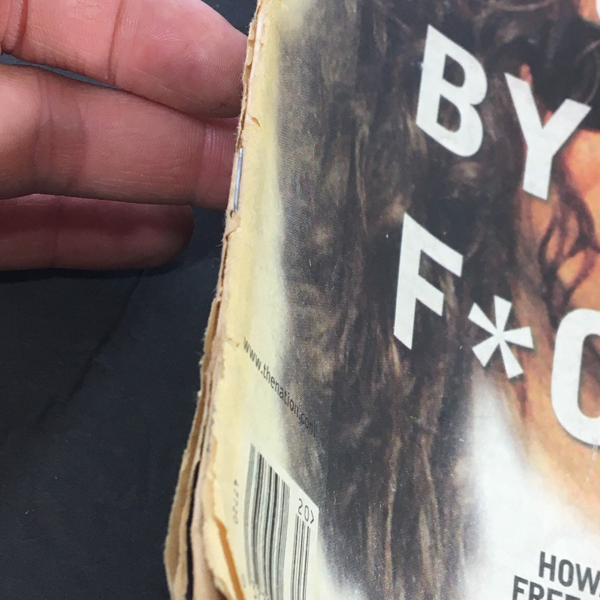 Close-up of the edge of The Nation Magazine dated May 17, 2004, showing the worn binding and the headline 'F*cked by the F*CC' from the cover.