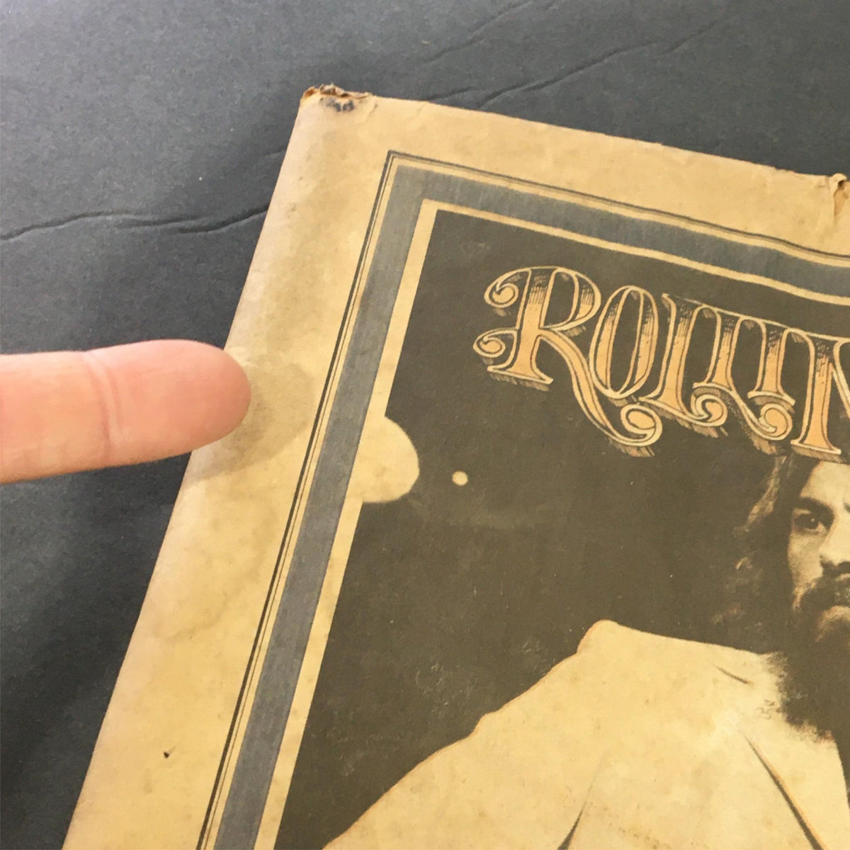 Close-up of the cover of VTG Rolling Stone Newspaper September 2 1971 #90 featuring George Harrison and Bob Dylan, highlighting minor wear and a pointing finger.
