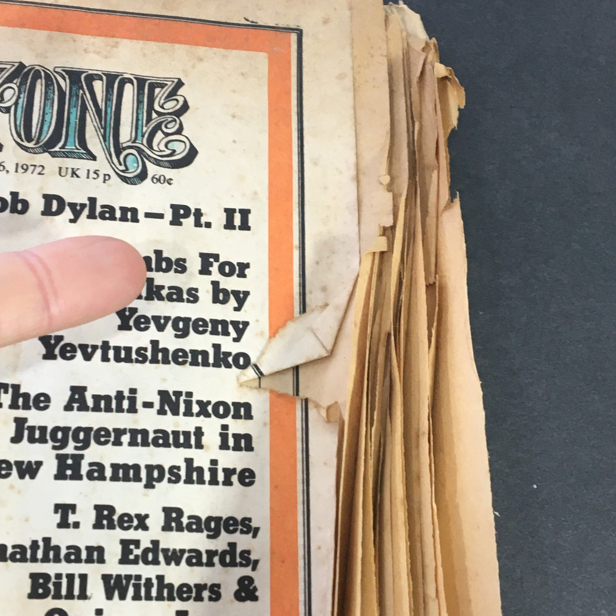 Close-up of the VTG Rolling Stone Newspaper March 16 1972 #104 highlighting article titles including 'Bombs For Balalaikas' and 'The Anti-Nixon Juggernaut in New Hampshire', pointing to interesting content within.
