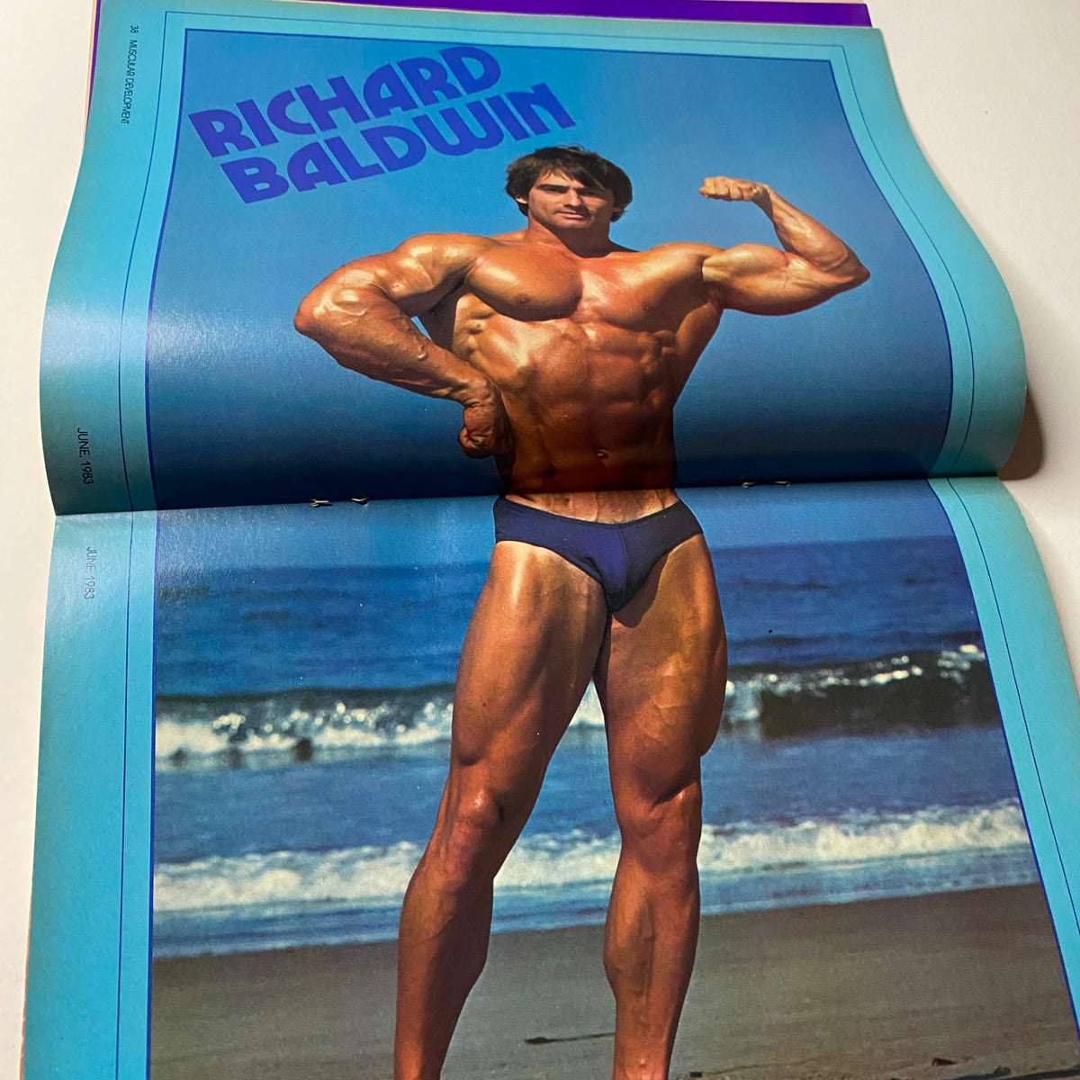 Centerfold page from Muscular Development Magazine June 1983 showcasing Richard Baldwin in a striking pose. This full-color spread illustrates Baldwin's impressive muscularity and classic bodybuilding form.