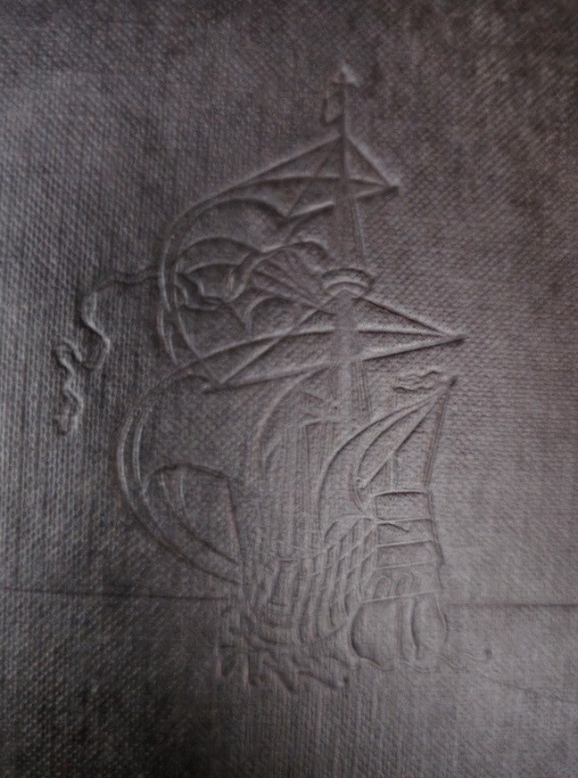 Close-up of the embossed design on the back cover of the VTG Horizon Magazine of Art, featuring a ship emblem.