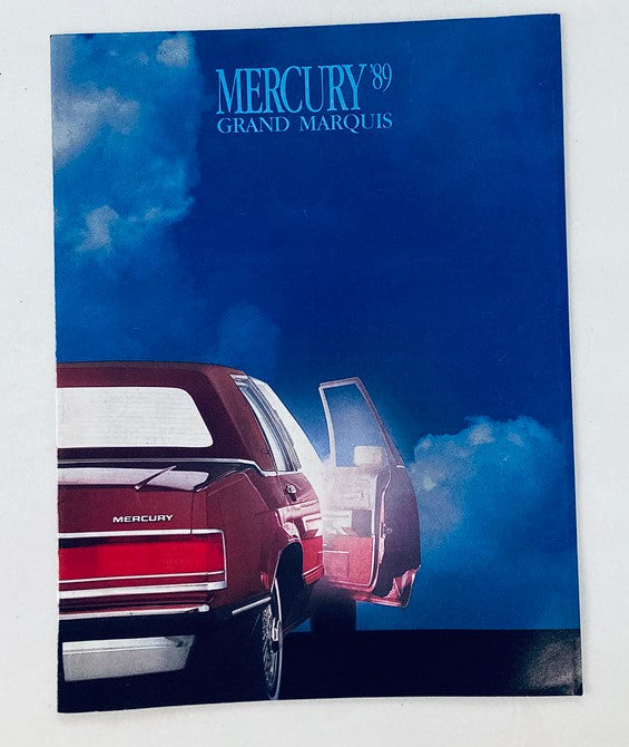 Cover of the 1989 Mercury Grand Marquis Dealer Showroom Sales Brochure Guide Catalog, featuring a striking image of the Mercury Grand Marquis car with an open door against a dramatic sky backdrop.