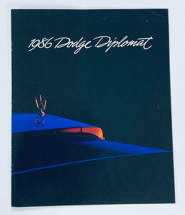 Cover image of the 1986 Dodge Diplomat Dealer Showroom Sales Brochure Guide Catalog, featuring a sleek design with a prominent car silhouette and artistic elements.