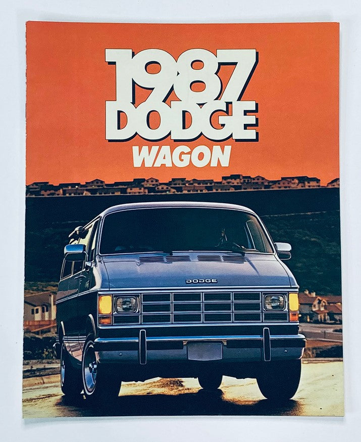 1987 Dodge Wagon Dealer Showroom Sales Brochure featuring a blue Dodge Wagon on a scenic road with an orange sunset backdrop, highlighting the vehicle's design and promoting the model.