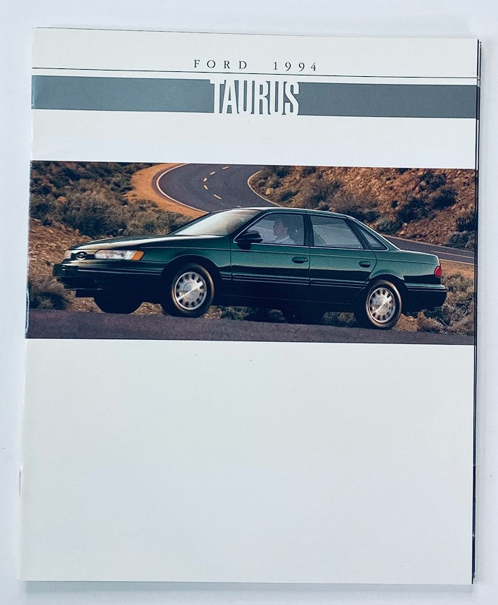 1994 Ford Taurus Dealer Showroom Sales Brochure showcasing a green Ford Taurus on a winding road, highlighting the design and features of the vehicle.