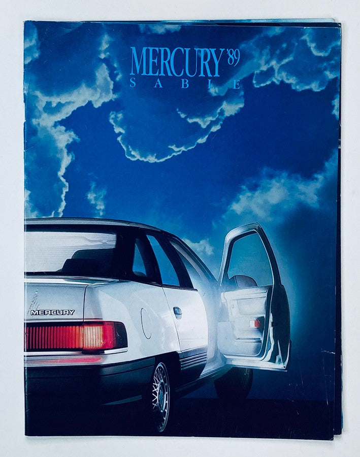 1989 Mercury Sable Dealer Showroom Sales Brochure Guide Catalog featuring a sleek view of the car with an open door against a dramatic cloud background.