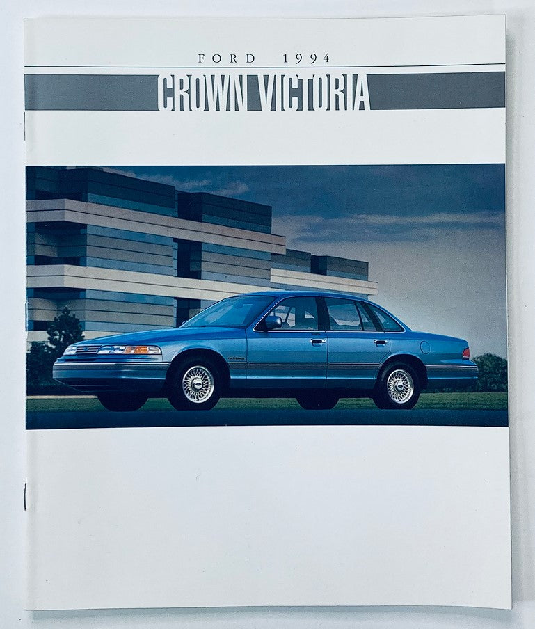 1994 Ford Crown Victoria Dealer Showroom Sales Brochure featuring a blue Ford Crown Victoria sedan with modern architectural background, showcasing the car's design and features in an informative promotional layout.