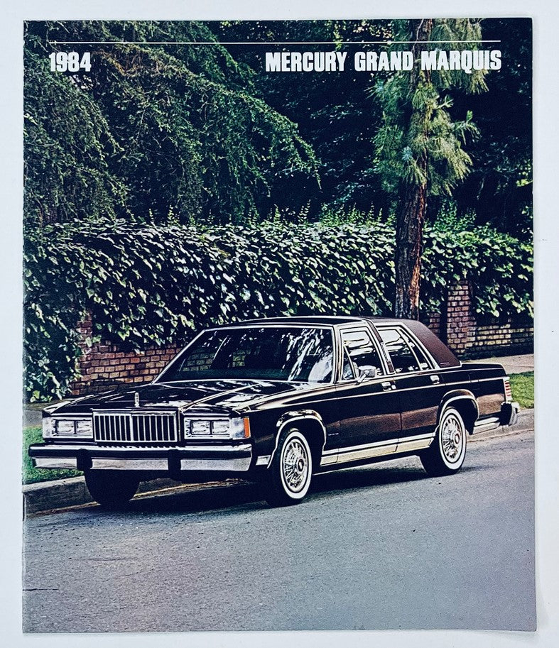 1984 Mercury Grand Marquis Dealer Showroom Sales Brochure Guide Catalog showcasing a black Mercury Grand Marquis parked on a tree-lined street.