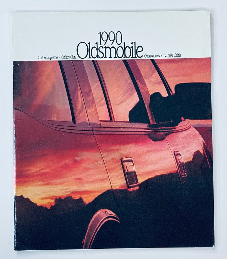 1990 Oldsmobile Outlass Cruiser Dealer Showroom Sales Brochure Cover featuring a sleek cutaway image of the vehicle against a colorful sunset backdrop.