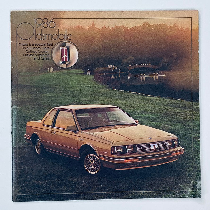 Cover of the 1986 Oldsmobile Cutlass Ciera Dealer Showroom Sales Brochure featuring a gold Oldsmobile Cutlass Ciera in front of a scenic landscape.