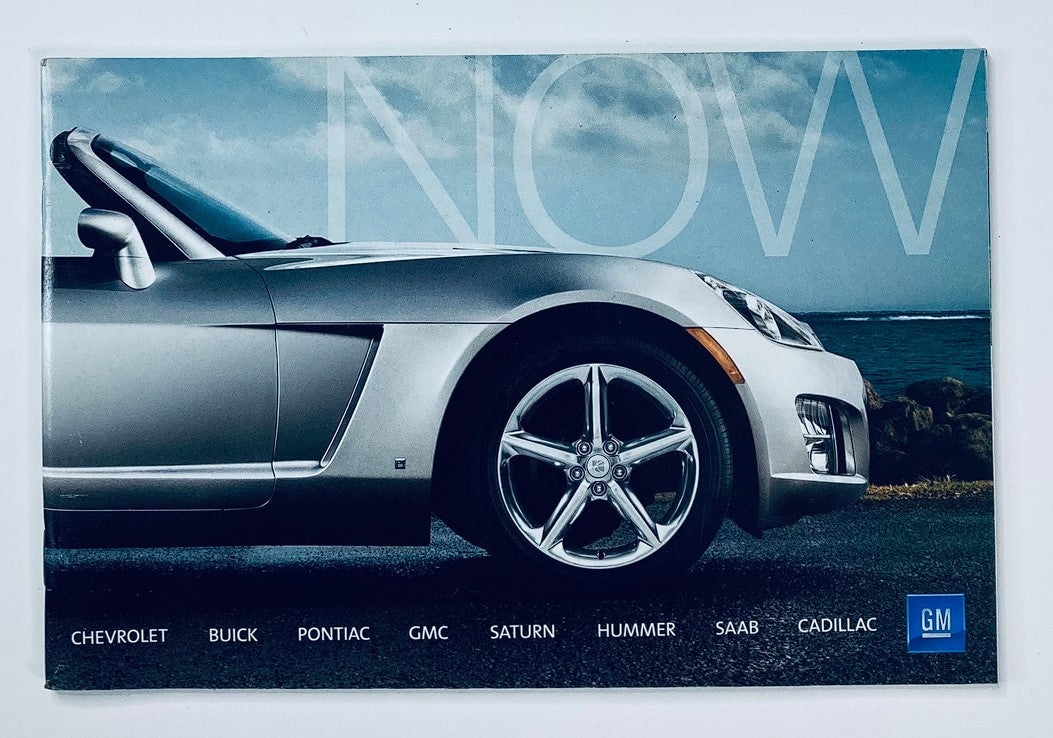 2000s GM Chevrolet, Buick Dealer Showroom Sales Brochure Guide Catalog showcasing a sleek silver convertible car against a scenic backdrop with the word 'NOW' prominently displayed.