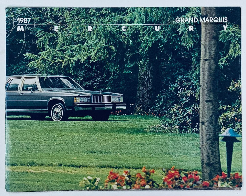 1987 Mercury Grand Marquis Dealer Showroom Sales Brochure Cover Featuring the 1987 Grand Marquis Vehicle Parked in a Lush Green Environment.