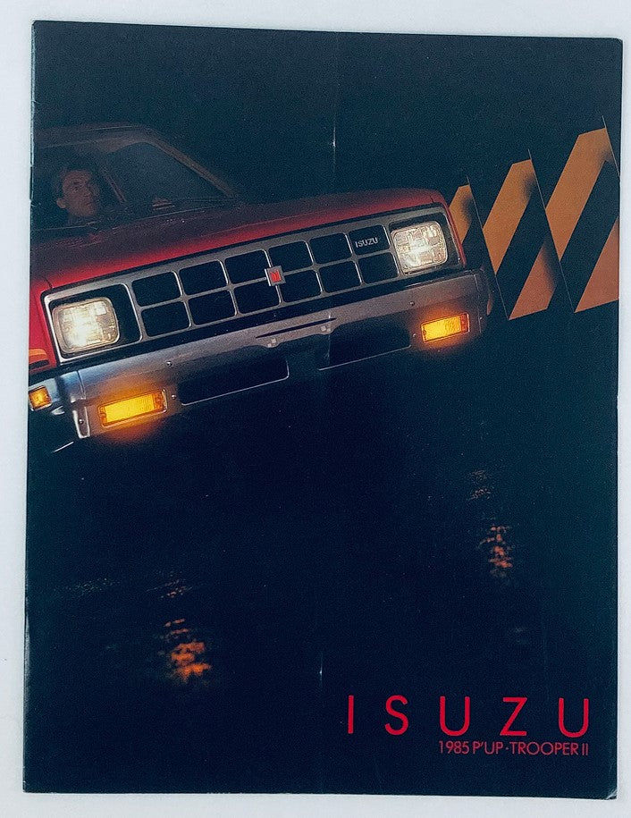 1985 Isuzu Pick-Up Trooper II Dealer Showroom Sales Brochure showcasing the vehicle with a dynamic image displaying the front view illuminated by headlights against a dark background.