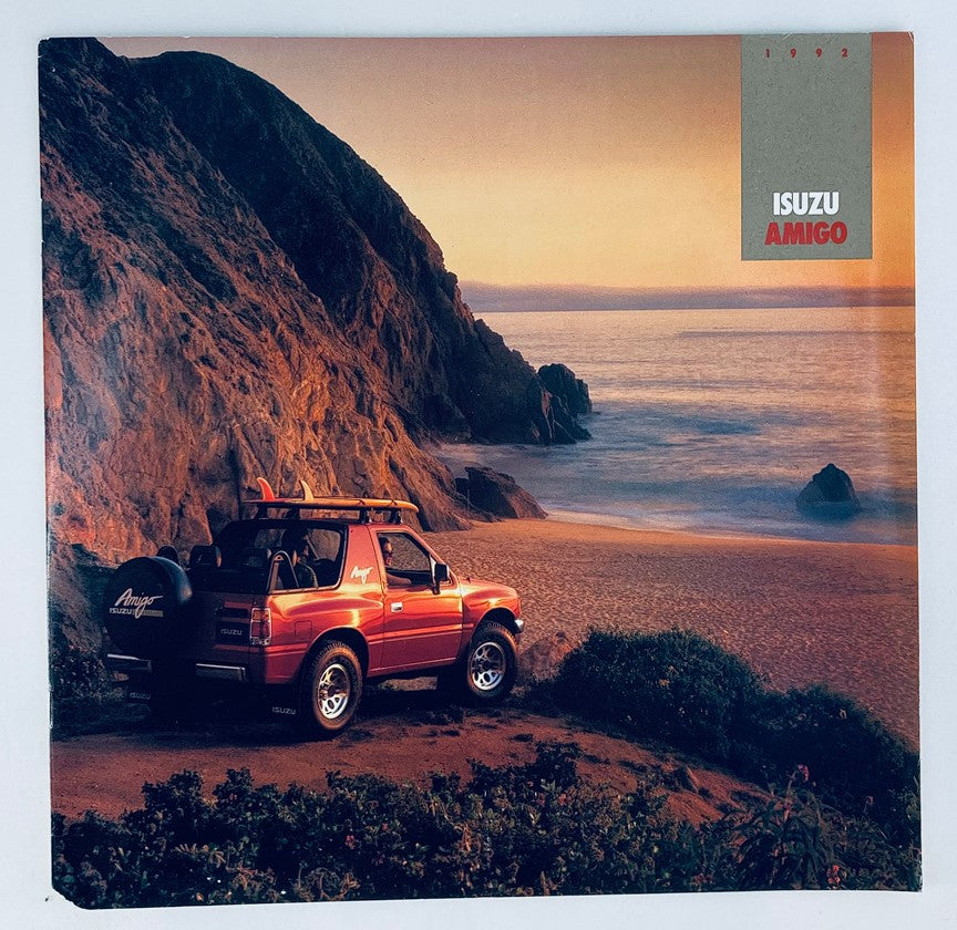 1992 Isuzu Amigo Dealer Showroom Sales Brochure Guide Catalog featuring a red Isuzu Amigo parked on a scenic beach during sunset.