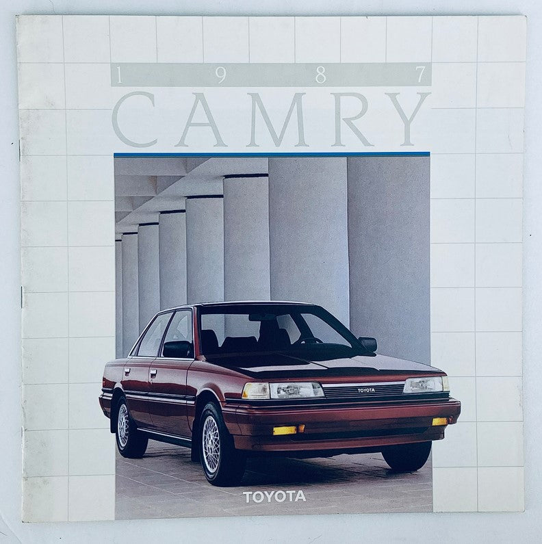 Cover image of the 1987 Toyota Camry Dealer Showroom Sales Brochure Guide Catalog featuring a red 1987 Toyota Camry in front of a modern architectural setting.