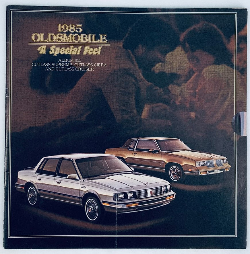 Cover of the 1985 Oldsmobile Cutlass Supreme Dealer Showroom Sales Brochure Guide Catalog featuring the Cutlass Supreme and Cutlass Cruiser, showcasing a sleek silver vehicle next to a stylish gold vehicle with a nostalgic background.