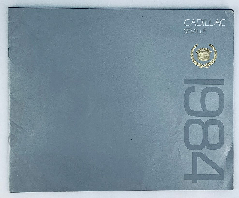 1984 Cadillac Seville Dealer Showroom Sales Brochure showcasing the cover design with sleek gray tones and gold emblem, perfect for collectors and automotive enthusiasts.