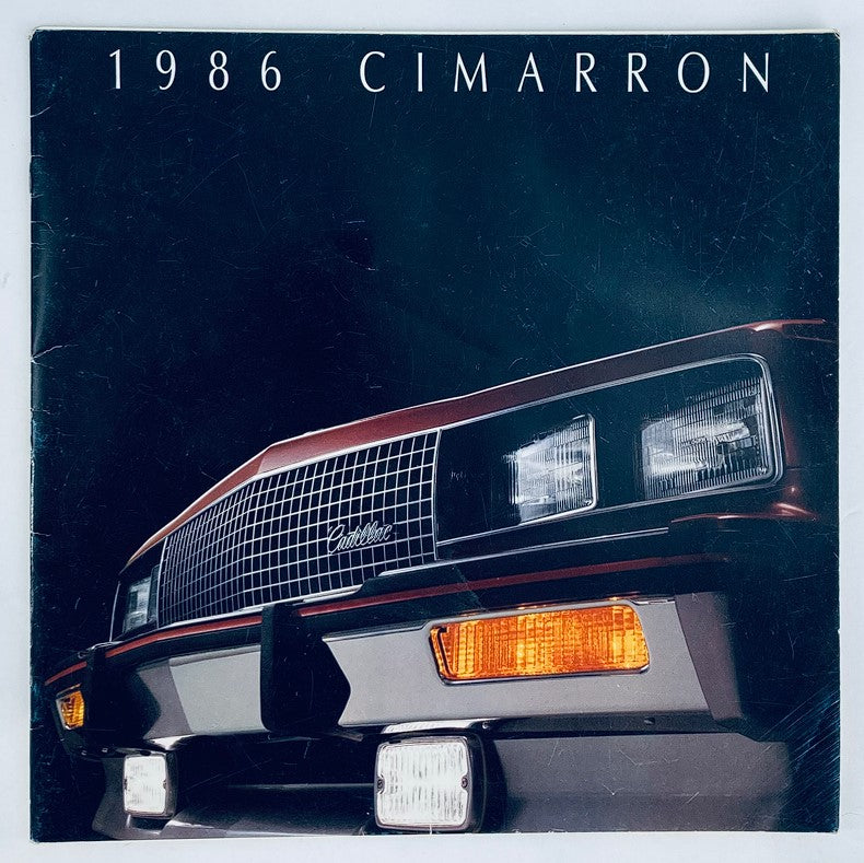 Front cover of the 1986 Cadillac Cimarron Dealer Showroom Sales Brochure Guide Catalog, featuring a close-up of the vehicle's grill and headlights.
