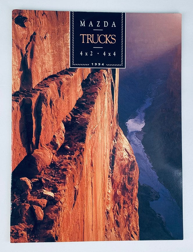 Cover of the 1994 Mazda Trucks 4x2 4x4 Dealer Showroom Sales Brochure, showcasing a rugged canyon landscape in warm tones.