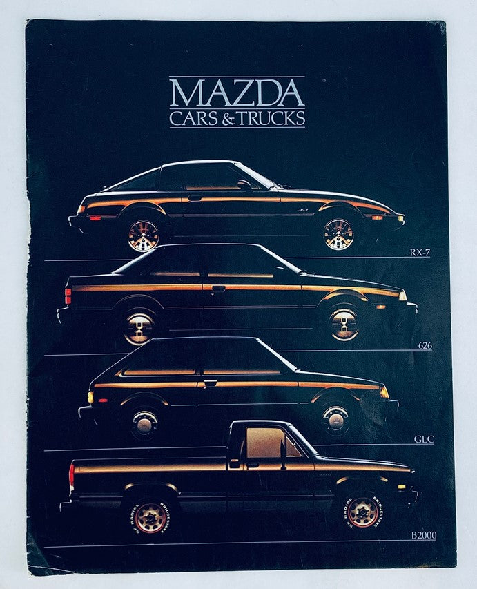 Front cover of the 1985 Mazda Cars & Trucks Dealer Showroom Sales Brochure Guide Catalog featuring sleek illustrations of Mazda RX-7, 626, GLC, and B2000 models in a stylish layout.