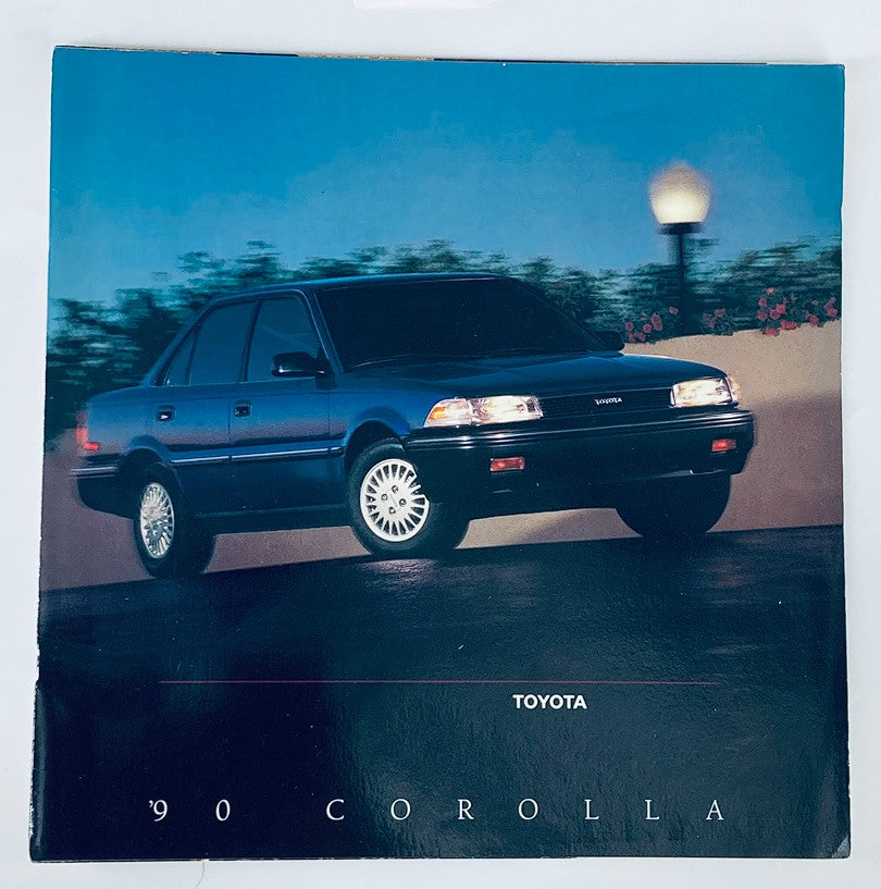 1990 Toyota Corolla Dealer Showroom Sales Brochure Guide Catalog featuring a sleek black Toyota Corolla model parked in an elegant outdoor setting.