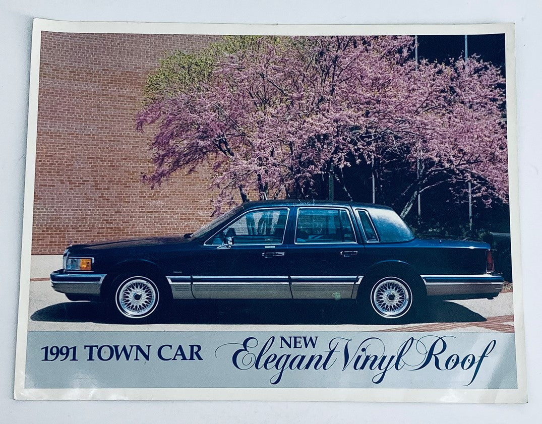 1991 Lincoln Town Car showcased in a promotional setting, featuring a new elegant vinyl roof, surrounded by blossoming trees, as seen in the dealer showroom sales brochure guide catalog.