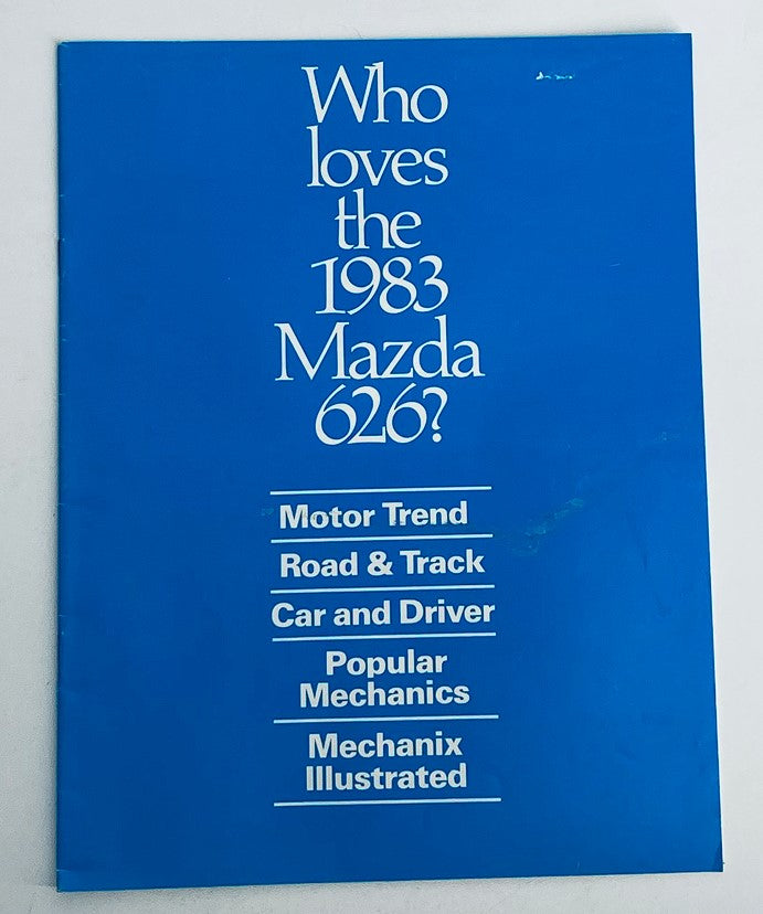 1983 Mazda 626 Dealer Showroom Sales Brochure Guide Catalog cover featuring the text 'Who loves the 1983 Mazda 626?' and logos from Motor Trend, Road & Track, Car and Driver, Popular Mechanics, and Mechanix Illustrated on a blue background.