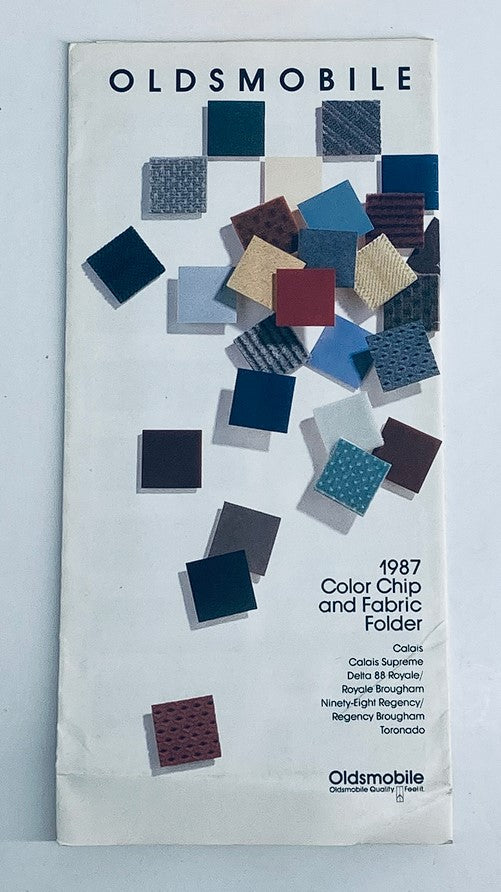 1987 Oldsmobile Color Chip & Fabric Folder Dealer Sale Brochure Guide Catalog featuring color samples and fabric swatches from Oldsmobile models including Calais, Delta 88 Royale, Royale Brougham, Ninety-Eight Regency, Regency Brougham, and Toronado.