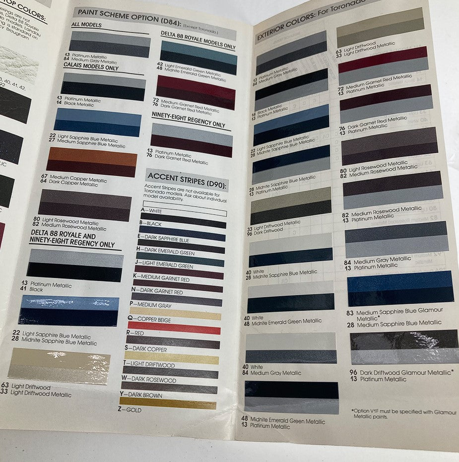 1987 Oldsmobile Color Chip & Fabric Folder Dealer Sale Brochure Guide Catalog displaying paint scheme options for Toronado models along with exterior color swatches and accent stripe colors.