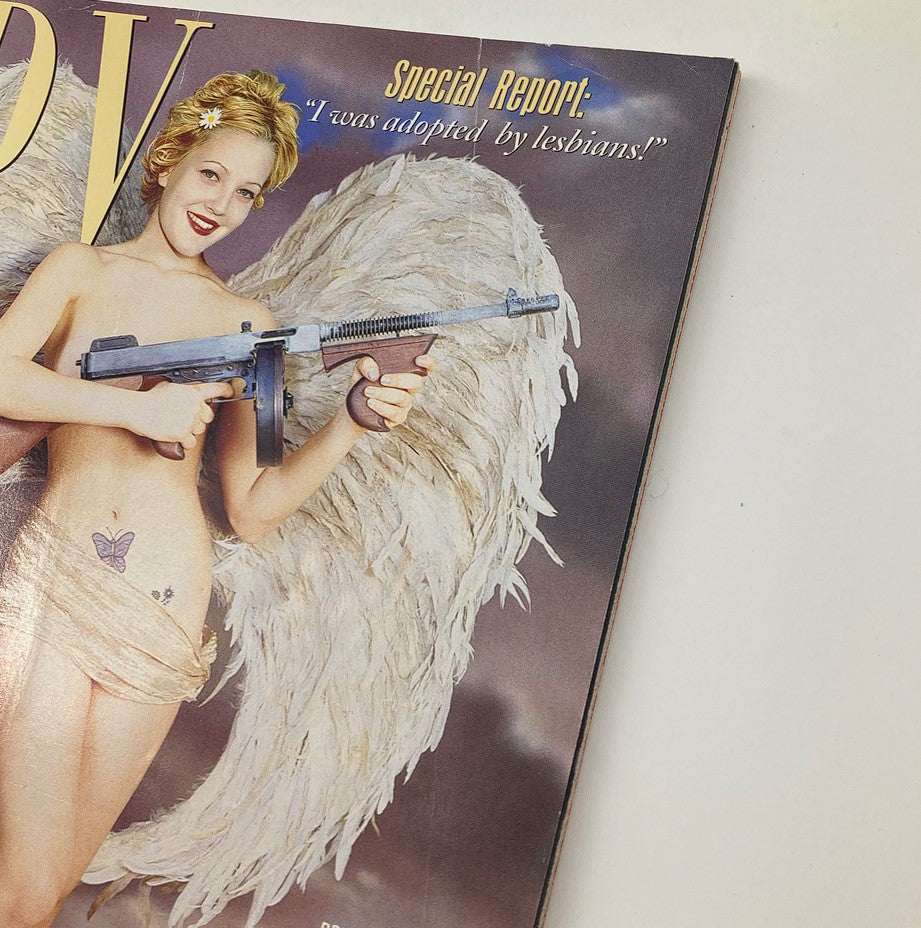 Cover of Spy Magazine March 1997 featuring a provocative image of a woman with angel wings and a gun, titled 'Drew Barrymore Makes Cupid Look Stupid.' This vintage magazine highlights the intersection of celebrity culture and satire.