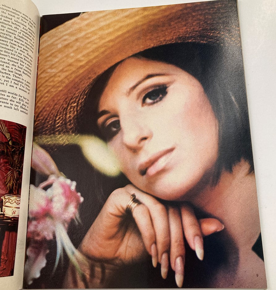 Close-up image of Barbra Streisand from the 1970 Hello Dolly Souvenir Program Book, with her wearing a straw hat and elegant makeup.
